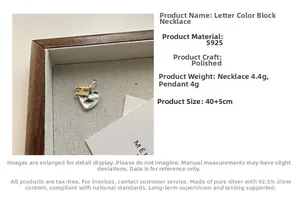 Macro detail of S925 silver two-tone H letter and heart pendant with dimensions