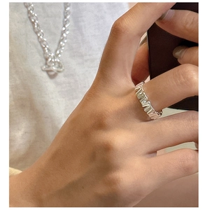 Detail of S925 sterling silver ring with unique vertical textured wave pattern on finger