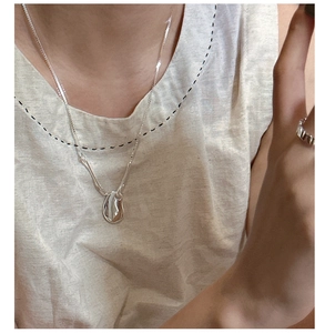 Detailed view of S925 silver irregular bean pendant and textured minimalist ring