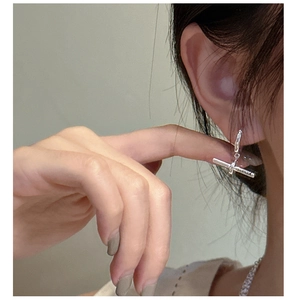 Gros plan sur les boucles d'oreilles barre en argent S925 avec gravure de lettres