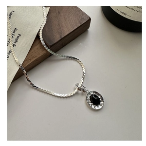 Detailed close-up of S925 sterling silver chain with black onyx wave pendant and hammered edge