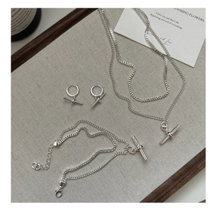 Gros plan sur un ensemble de bijoux en argent S925 avec pendentifs en barre T élégants