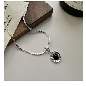 Macro detail of S925 sterling silver hammered pendant with black agate on vintage chain