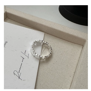 Macro detail of silver geometric vertical textured ring with polished metallic finish