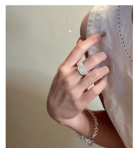 Dettaglio dell'anello a stella in argento S925 e bracciale a catena spessa indossati