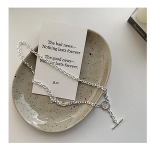 Close-up of S925 sterling silver chain necklace with OT toggle clasp on ceramic plate