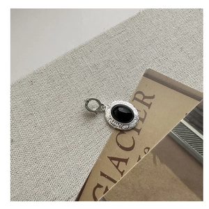 Macro detail of S925 silver necklace with black agate stone and engraved scroll patterns