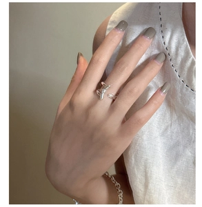 Detail of S925 silver ring featuring a minimalist cross-wrap design on a model's hand