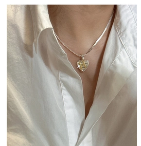 Detail of S925 silver heart locket pendant with gold letter H on a snake chain necklace