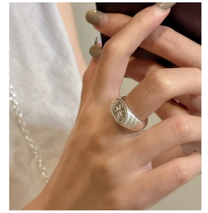 Dettaglio dell'anello a stella in argento s925 con texture architettoniche e zircone
