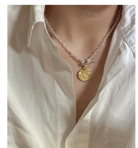 Detailed view of two-tone S925 sterling silver necklace with OT buckle and coin pendant