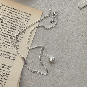 S925 sterling silver necklace with embossed barrel bead pendant on vintage paper