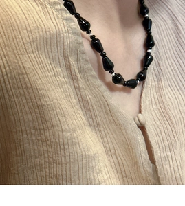 Detail of s925 silver necklace featuring black waterdrop beads and silver spacers