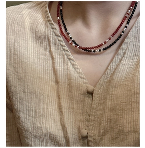 Detail of layered S925 silver beaded necklaces with red agate and black spinel stones