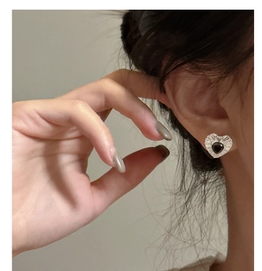 Detailed close-up of S925 silver heart stud earrings with black zircon and textured finish