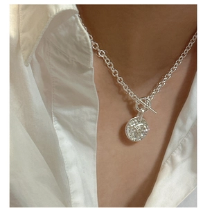 Macro detail of silver S925 necklace with hammered pendant and classic OT toggle clasp