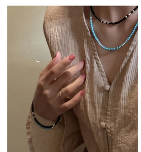 Close-up of layered S925 silver beaded necklaces with turquoise and black agate stone beads