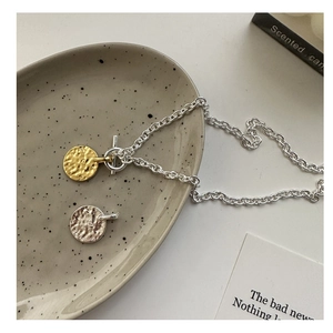 Close-up of S925 silver OT clasp necklace with textured gold and silver coin pendants