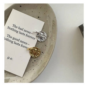 Detail of S925 sterling silver hammered coin pendants with unique textured finish and engravings