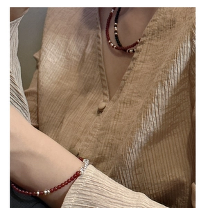 Detailed view of s925 silver beaded necklace with red agate stones on a model