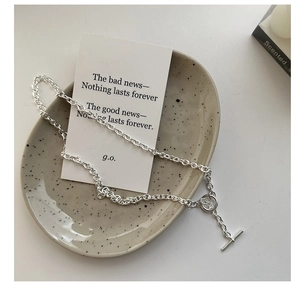 Detailed close-up of a silver S925 sterling silver chain necklace with an OT toggle clasp