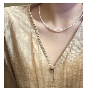 Dettaglio della collana a sfere in argento S925 minimalista sulla clavicola di una modella
