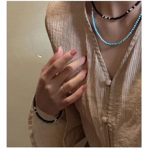 Detail of s925 silver beaded necklaces with black agate and turquoise on a model