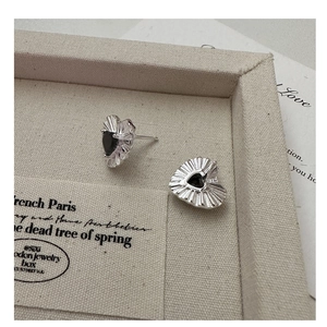 Macro view of S925 sterling silver heart studs with black zircon and radiant texture