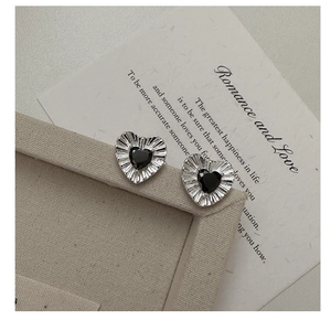 Detailed close-up of S925 silver heart studs with black zircon and pleated metal edges