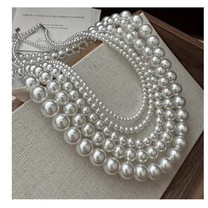 Dettaglio di collana in argento a più strati con perle bianche sfumate lucide su espositore