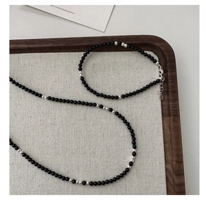 Detailed macro view of S925 silver beaded necklace with black agate and heart charm