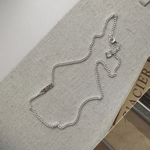 Vintage S925 sterling silver necklace with engraved pattern on grey linen surface