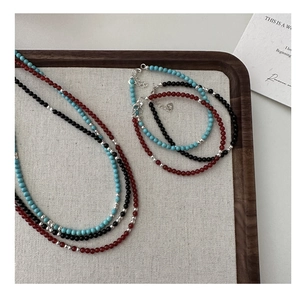 Detailed shot of s925 silver beaded bracelets with turquoise and agate in a wooden tray