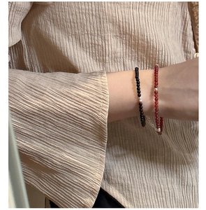 Detail of s925 silver beaded bracelets set featuring delicate red agate and onyx stones