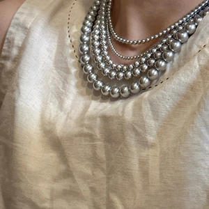 Collier à plusieurs rangs en perles d'argent polies sur fond en tissu texturé