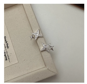 Detail of silver S925 star stud earrings with textured dual four-pointed star design