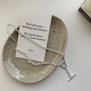 Minimalist S925 sterling silver two-tone OT toggle clasp necklace on a ceramic tray