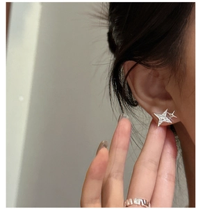 Detail of s925 silver star stud earrings with pavé zircons on a model's ear