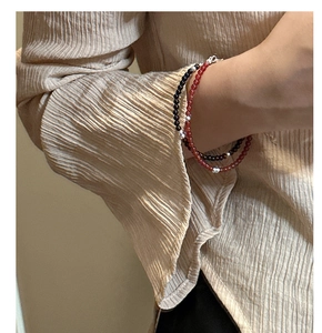 Close-up of s925 silver beaded bracelet with black and red agate on a model's wrist
