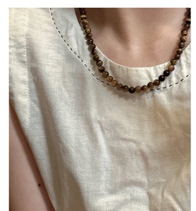 Close-up of S925 sterling silver tiger eye beaded necklace worn on a model's neck