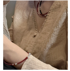 Detail of s925 silver beaded bracelet and layered agate necklace on a model