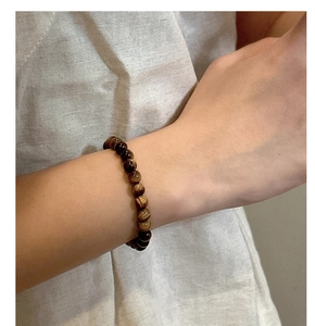 Detailed close-up of tiger eye stone beaded bracelet with natural polished brown textures
