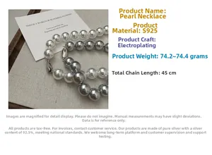 Macro shot of 45cm S925 silver necklace with white and grey pearls on textured fabric