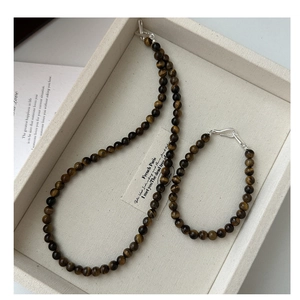 Close-up of S925 silver tiger eye stone necklace and bracelet set with metal clasp