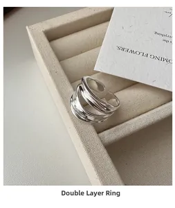 Macro view of minimalist S925 sterling silver double layer open ring on beige velvet