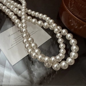 Collier élégant en argent S925 avec perles blanches brillantes sur un fond vintage