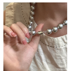 Detail of a large 12mm silver mirror finish sphere necklace with a sleek oval clasp