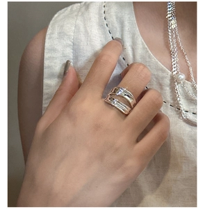 Close-up of a double-layered irregular fluid silver ring worn on index finger