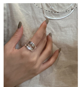 Detail of s925 silver double-layered wavy ring showing irregular polished curves on hand