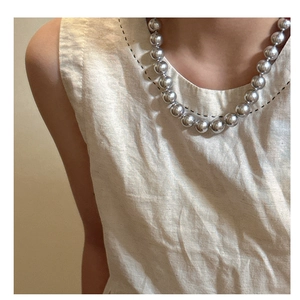 Close-up of S925 sterling silver necklace with large round beads on a model's neckline